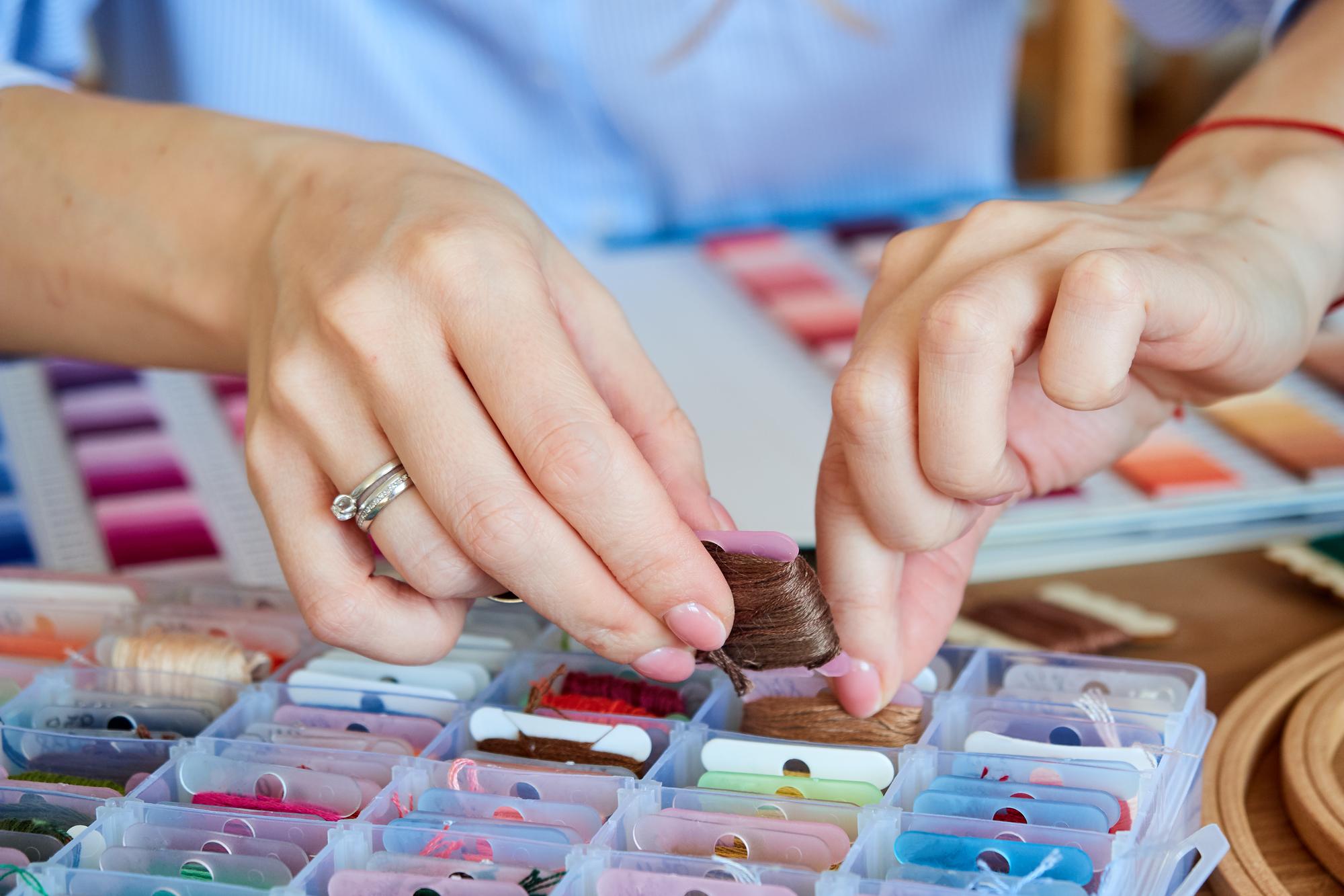Staff member preparing embroidery sample at workstation